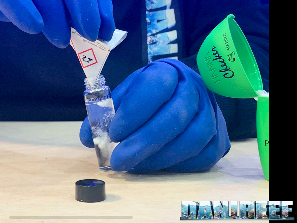 La fase 6 della procedura. Il reagente in polvere viene inserito nella cuvette con l'acqua da analizzare.
