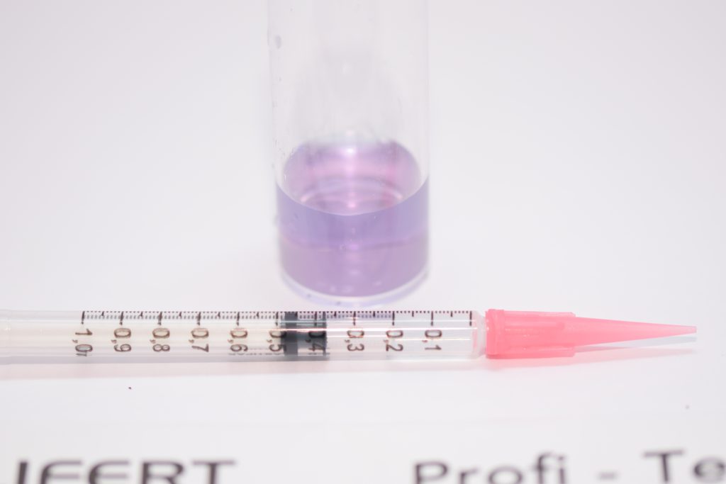 Acqua con reagente del Test Salifert KH prima dopo il cambio di colore. Dettaglio sulla siringa per la quantità di liquido rimanente.